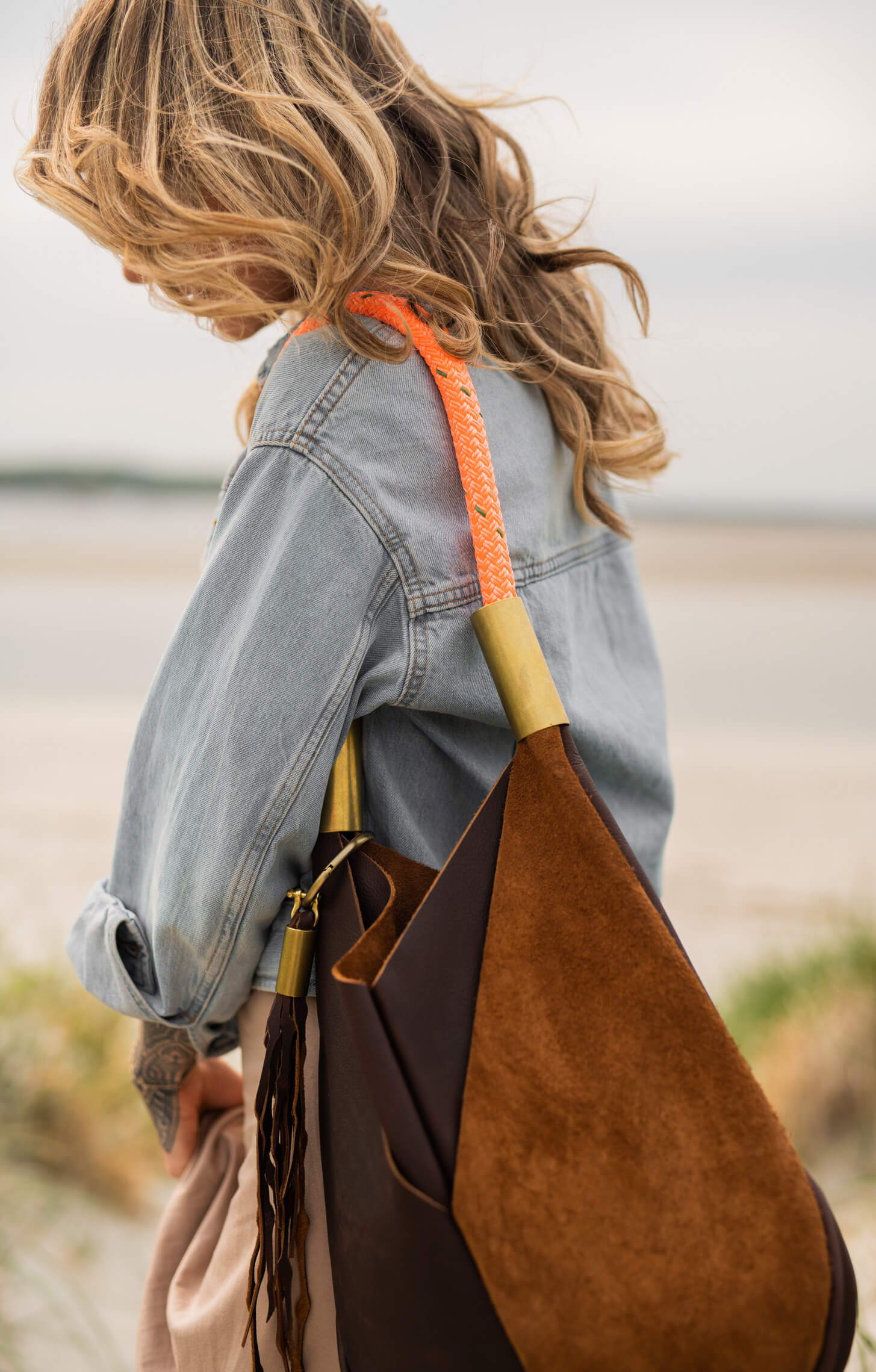woman wearing brown leather bag with neon orange dock line