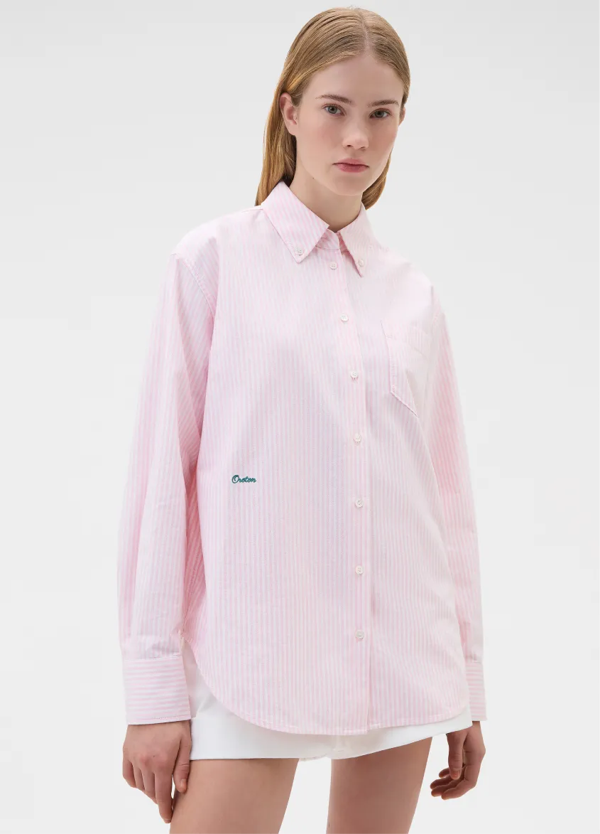 A model wearing a pink button-up shirt with a collar.