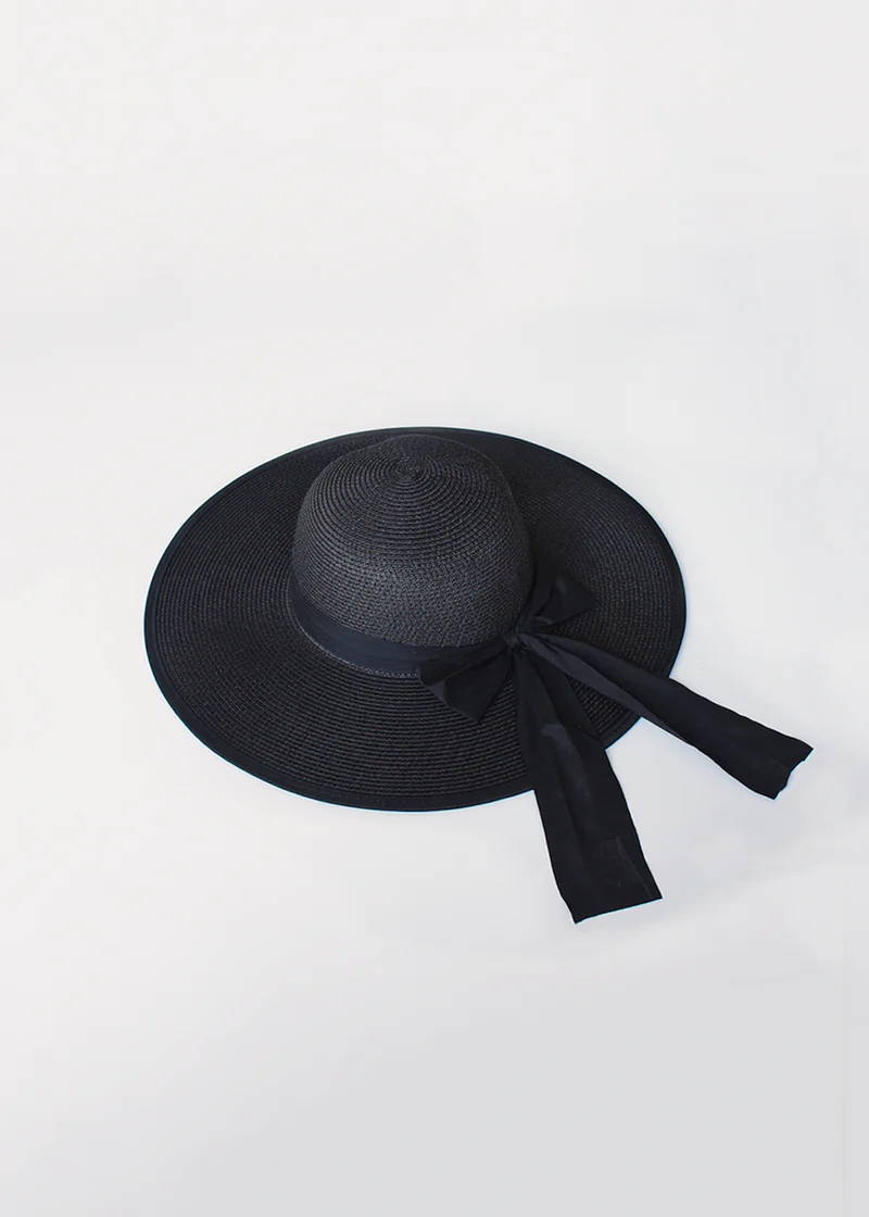 A black wide brimmed wicker hat with ribbon detail