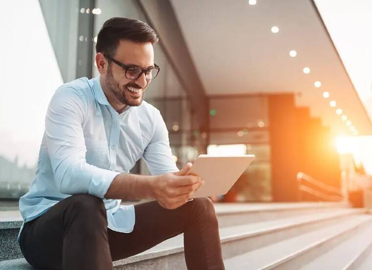 Smiling man holding a tablet