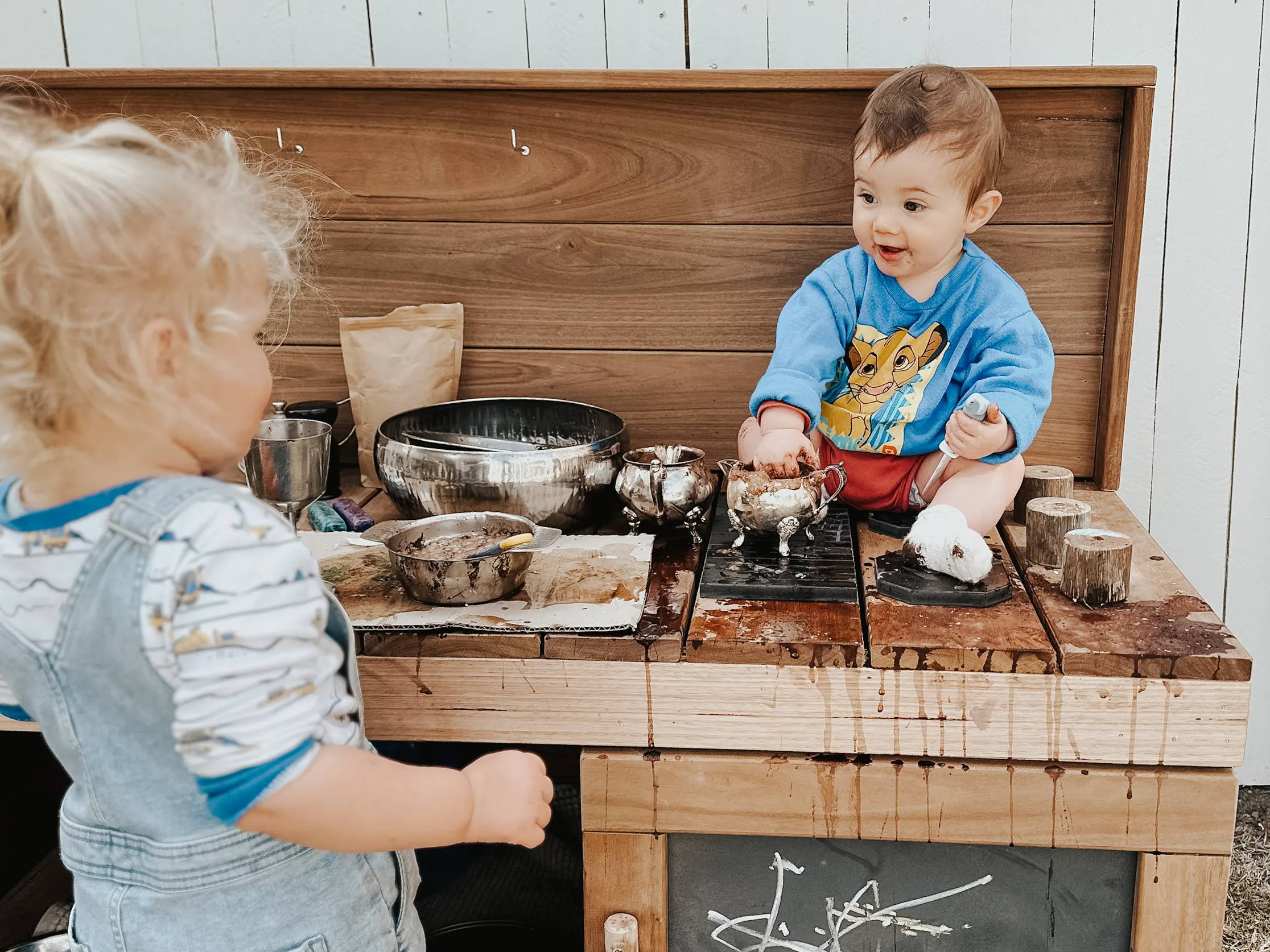 Kids having a muddy play at a mud kitchen