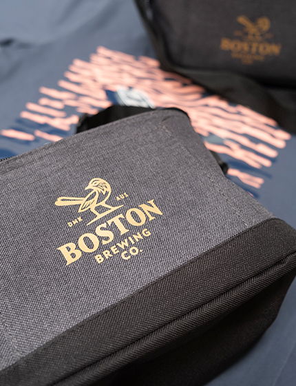Grey cooler bag with a gold Boston Brewing Co. logo DTF transfer on the front panel