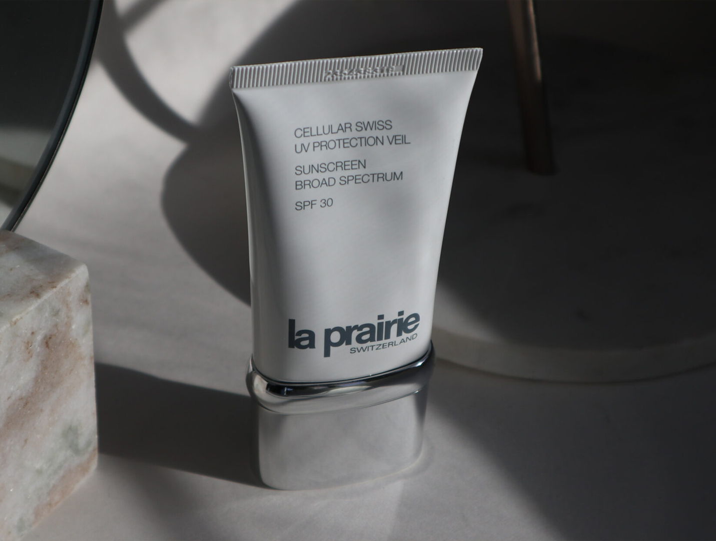 Tube of la prairie skincare product on a surface with soft lighting.