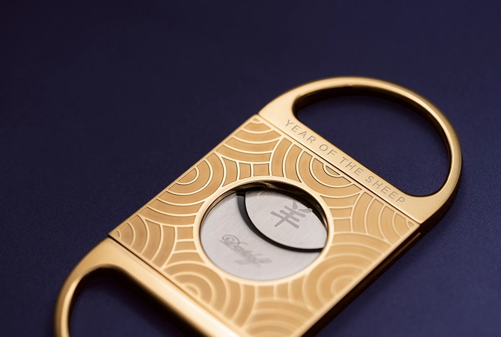 Der goldene Double Blade Cutter auf lila Hintergrund.