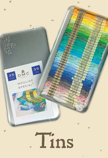 A collection of colorful threads in a silver tin with packaging.