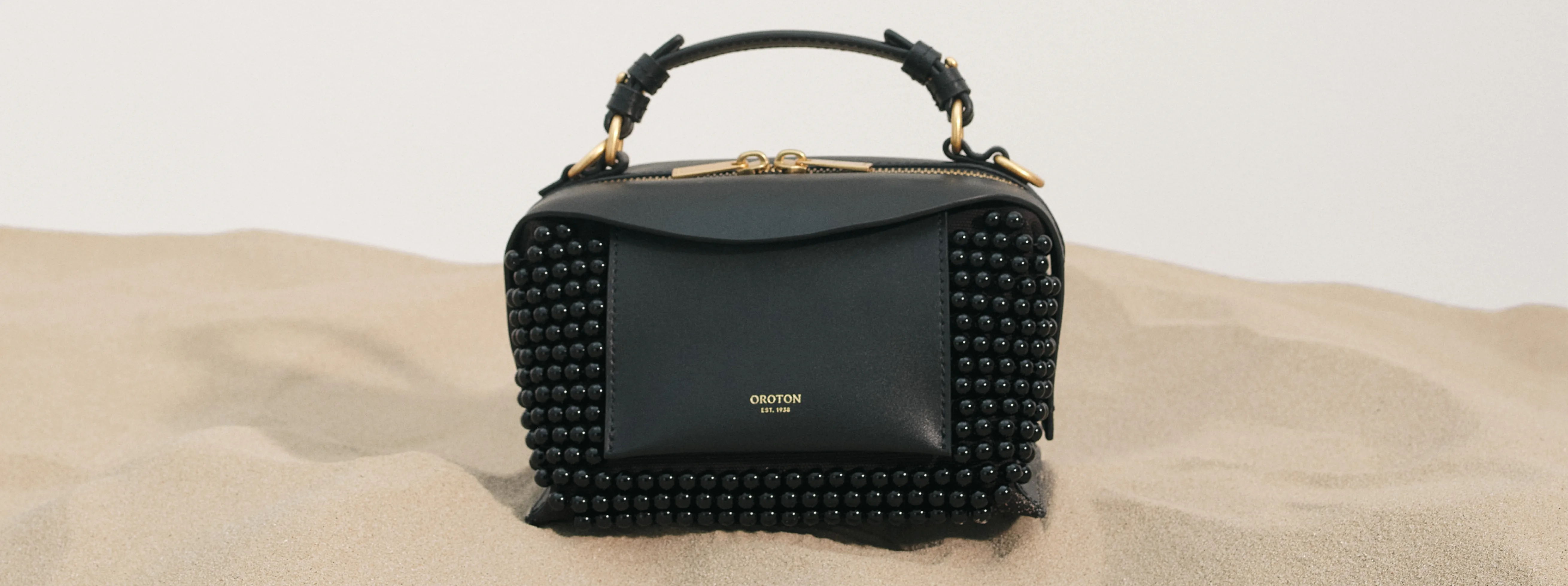A stylish black handbag with a unique textured design.