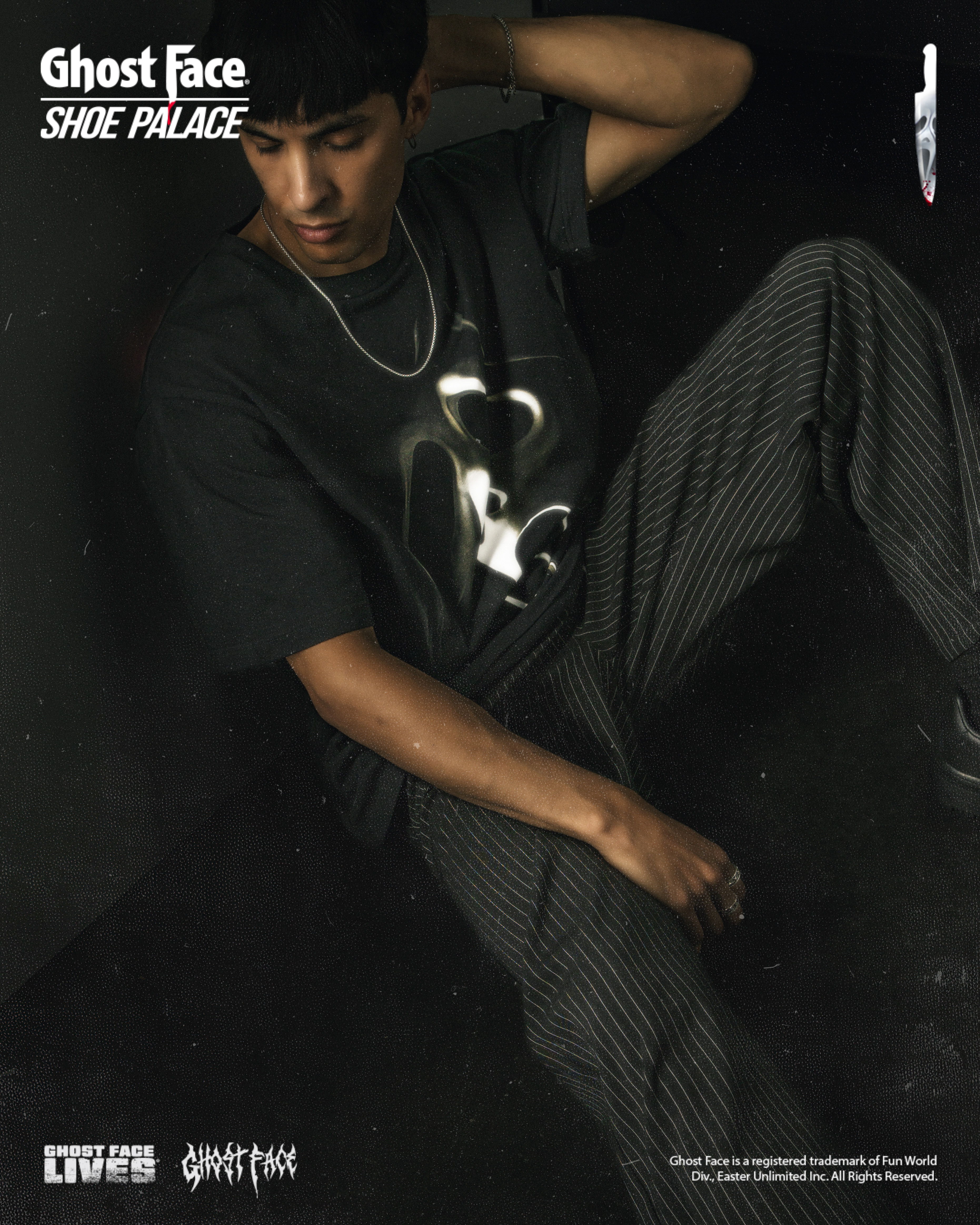 Person wearing a Ghost Face shirt, sitting against a dark background.
