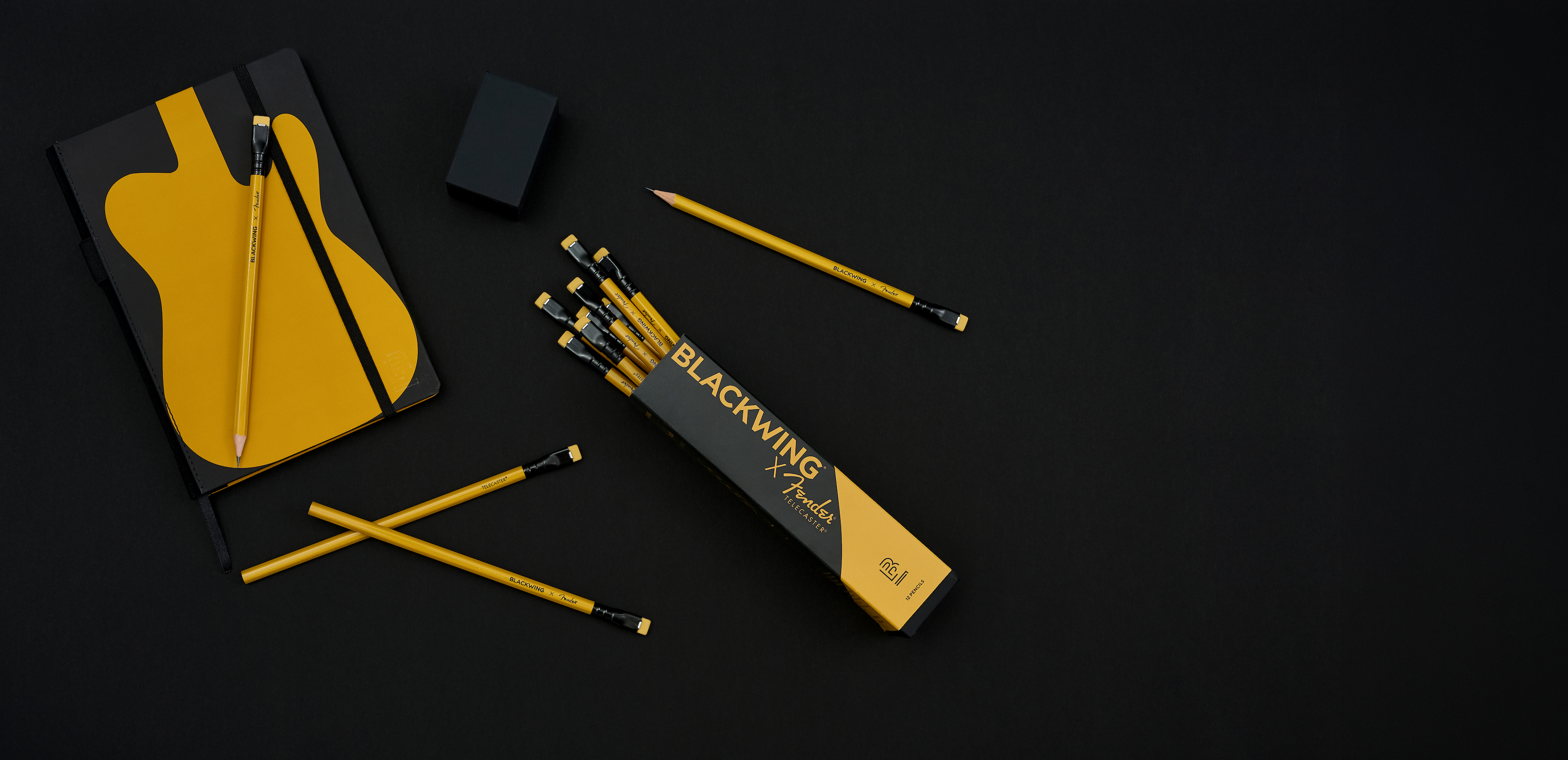 Guitar-themed stationery set on a black background with yellow accents.