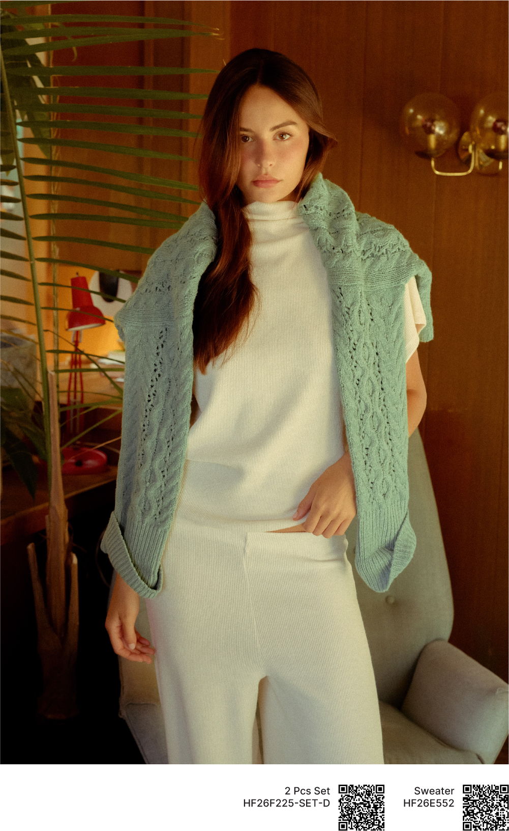 Woman wearing a light blue shawl over a white outfit in a cozy setting.