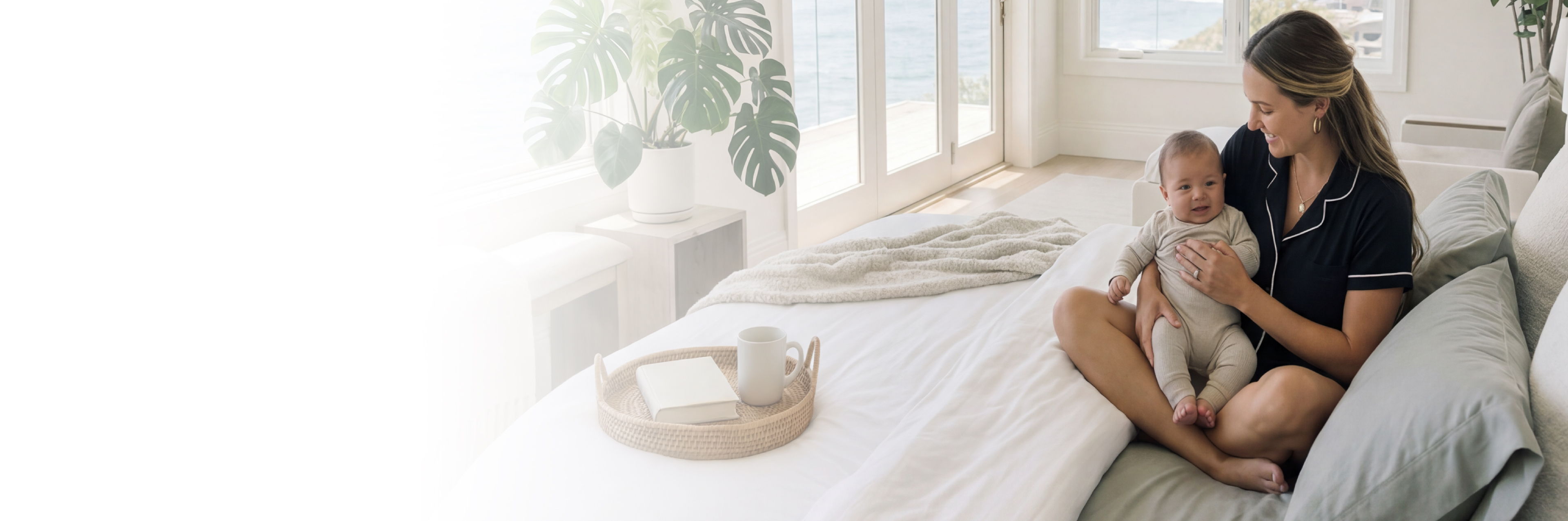 a woman sitting on a bed holding a baby