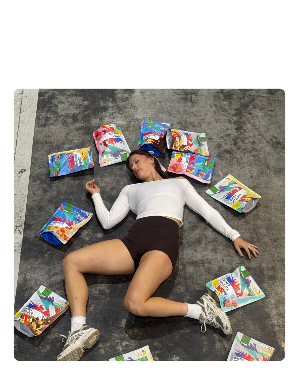Person lying on the ground surrounded by colorful snack packages.