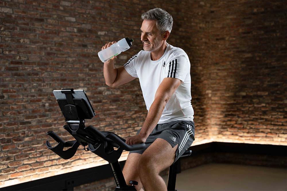 Man sipping water while riding upright on IC5 Indoor Cycle