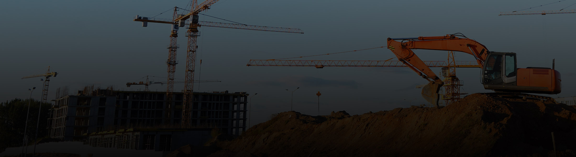 Construction site with cranes, excavator, and building in progress, representing security and monitoring solutions for the construction industry