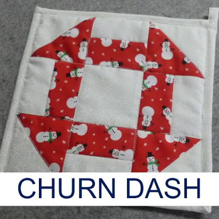 Churn dash quilt block made into a hot pad made out of holiday fabrics 