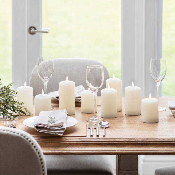 LED candles on a dining table with wine glasses and cutlery.