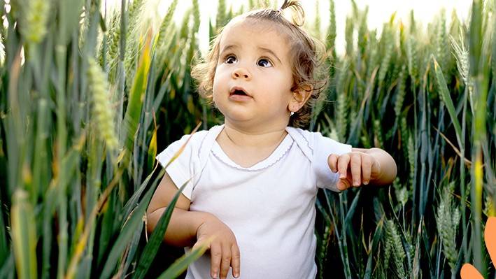 A baby in a field of Grass- Babo Botanicals