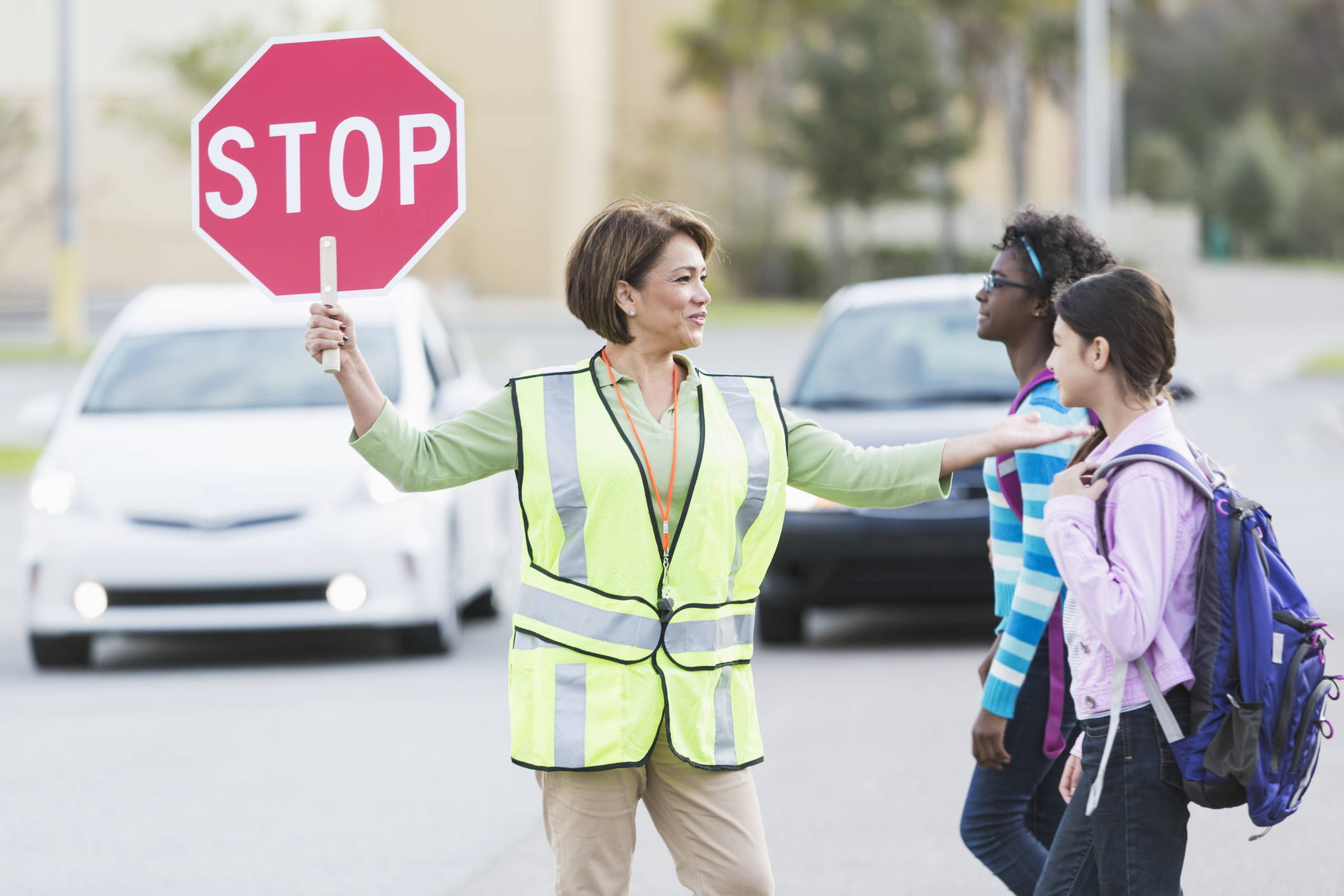 School crossing guard and students using crosswalk