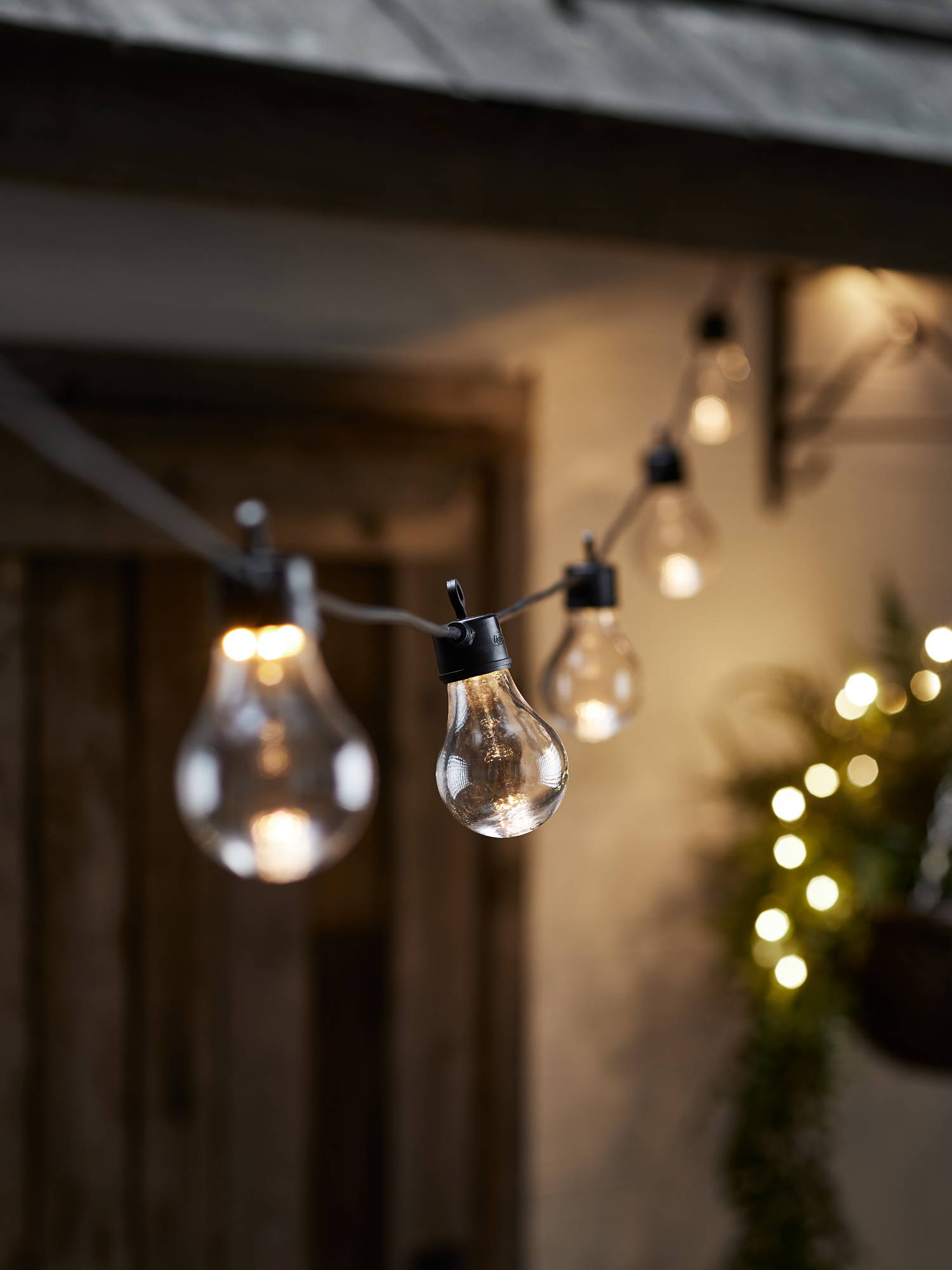 Black festoon lights draped from the house