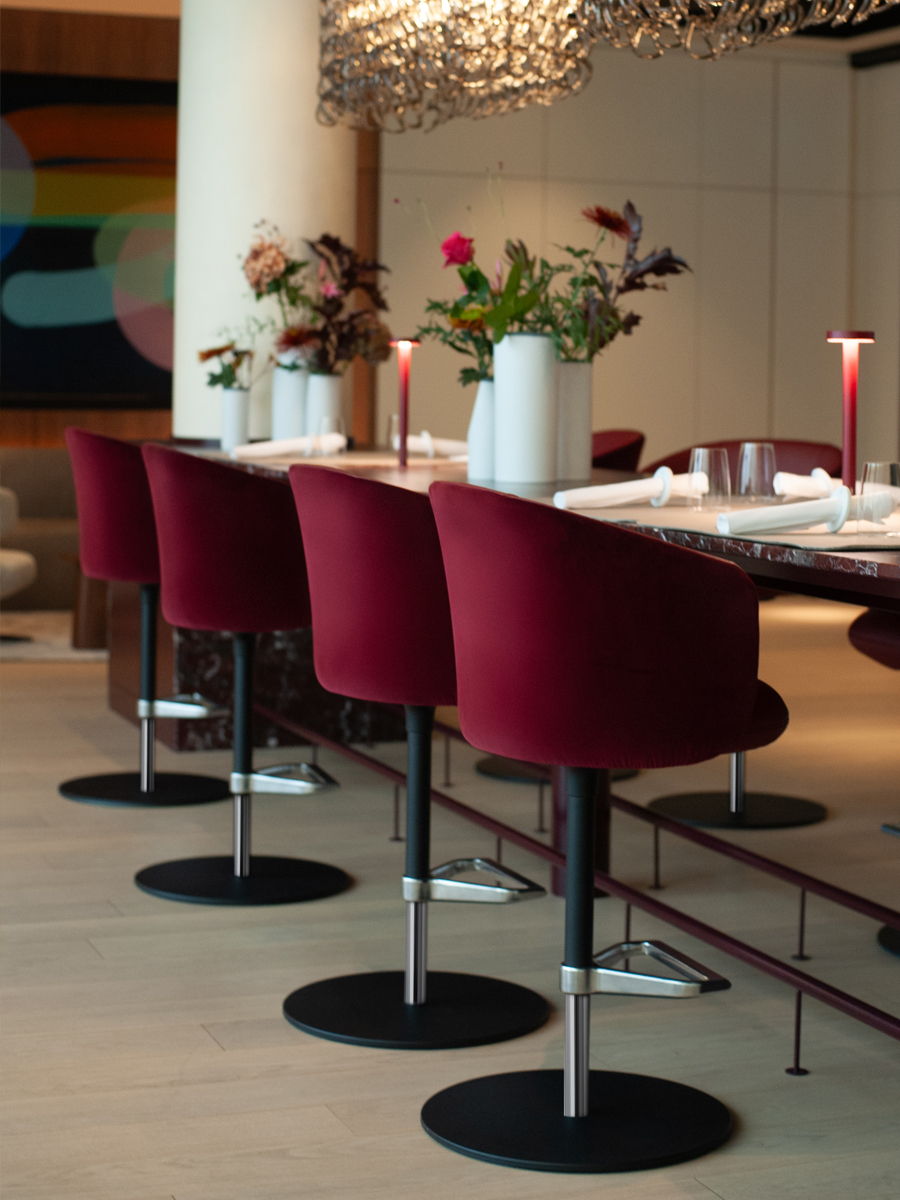 Modern white Mikado swivel chair by Vitra beside a wooden table with a floral arrangement.