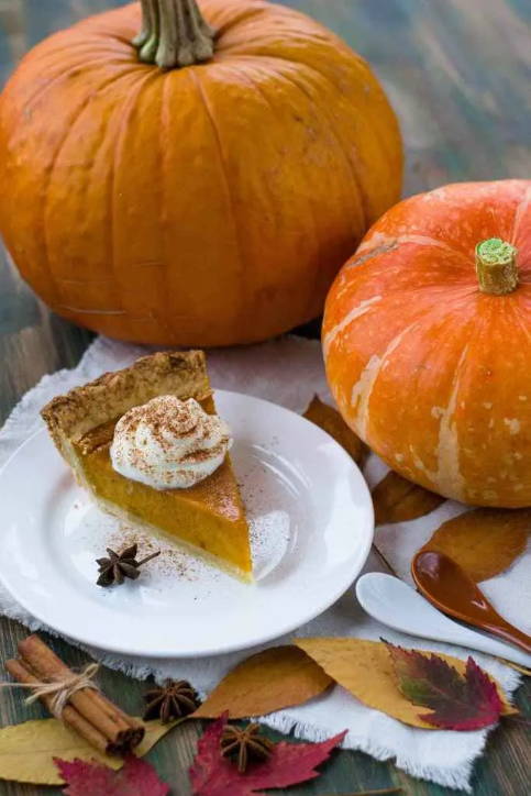Image of two pumpkins and a slice of pumpkin pie.