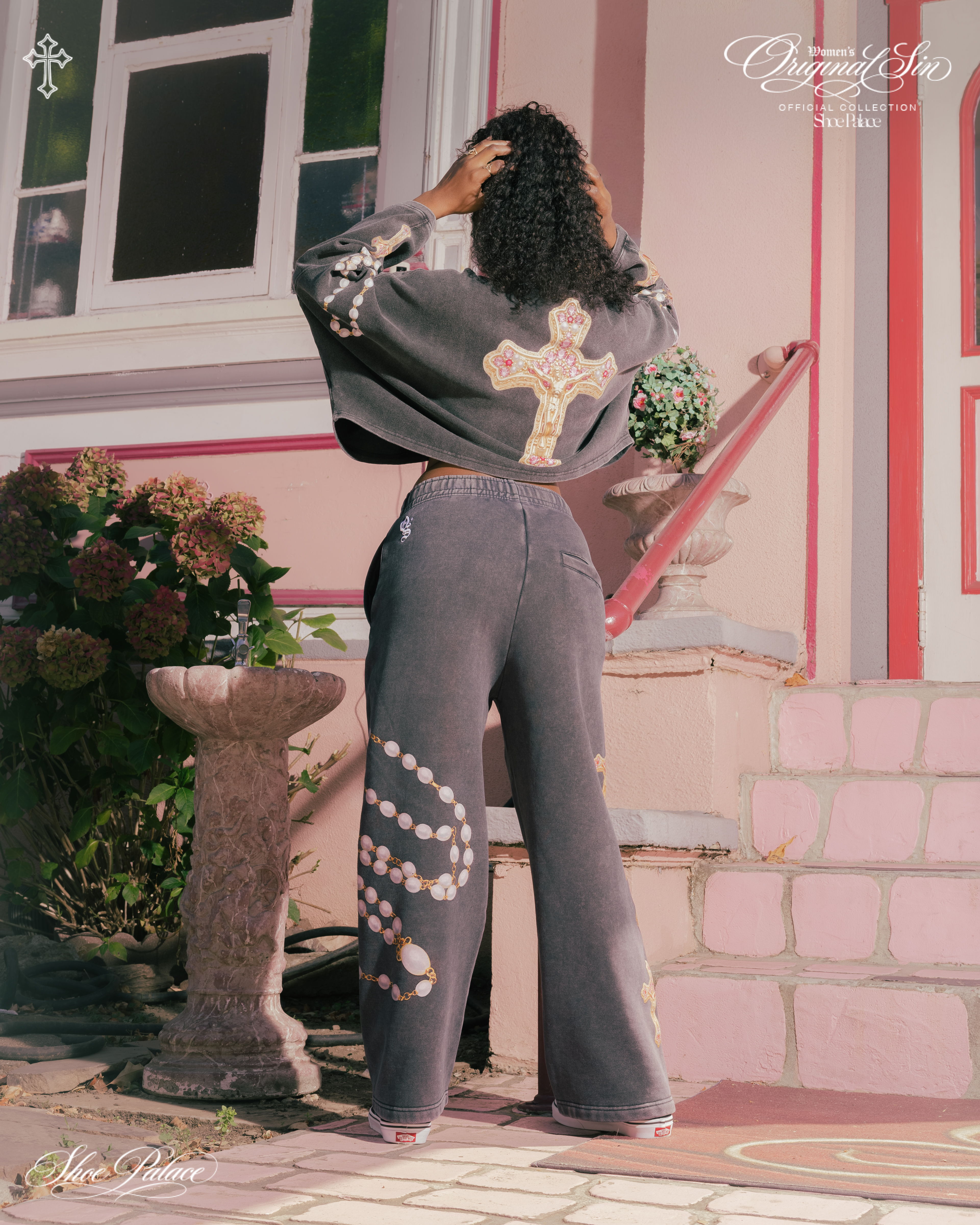 Person wearing a stylish outfit, standing outside near a decorative stone.