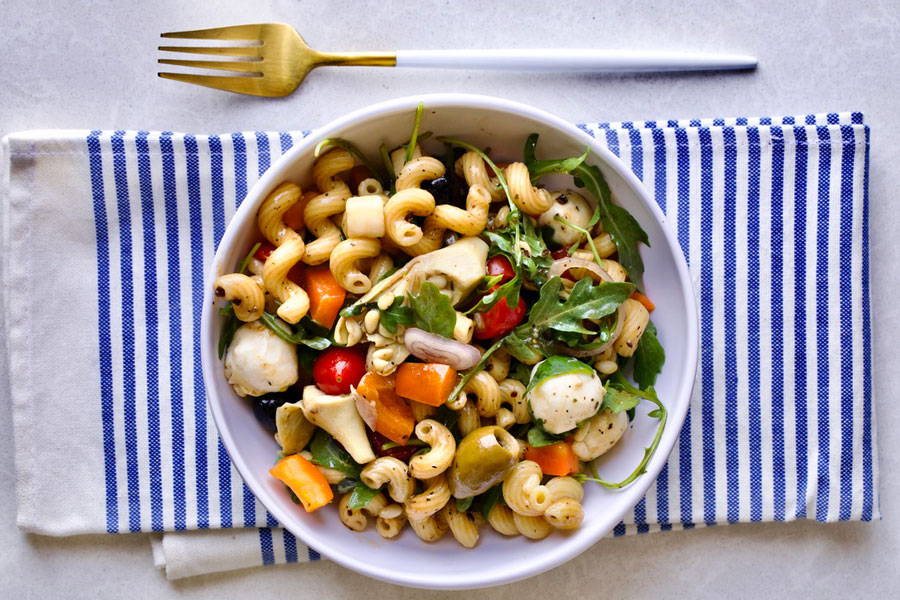 Pasta salad made with cavatappi pasta and assorted veggies served in a bowl
