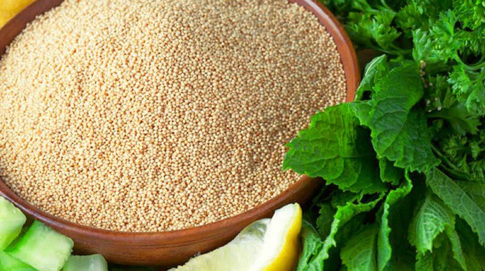 Bowl of amaranth seeds surrounded by mint, parsley and a lemon wedge | Health Benefits Of The Superfood Amaranth | amaranth color | Featured