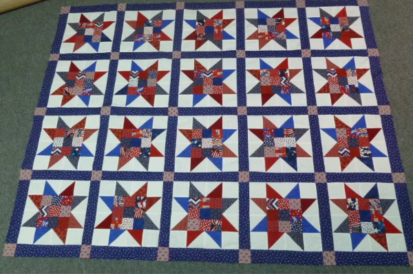 a big quilt in red and blue with blue sashing