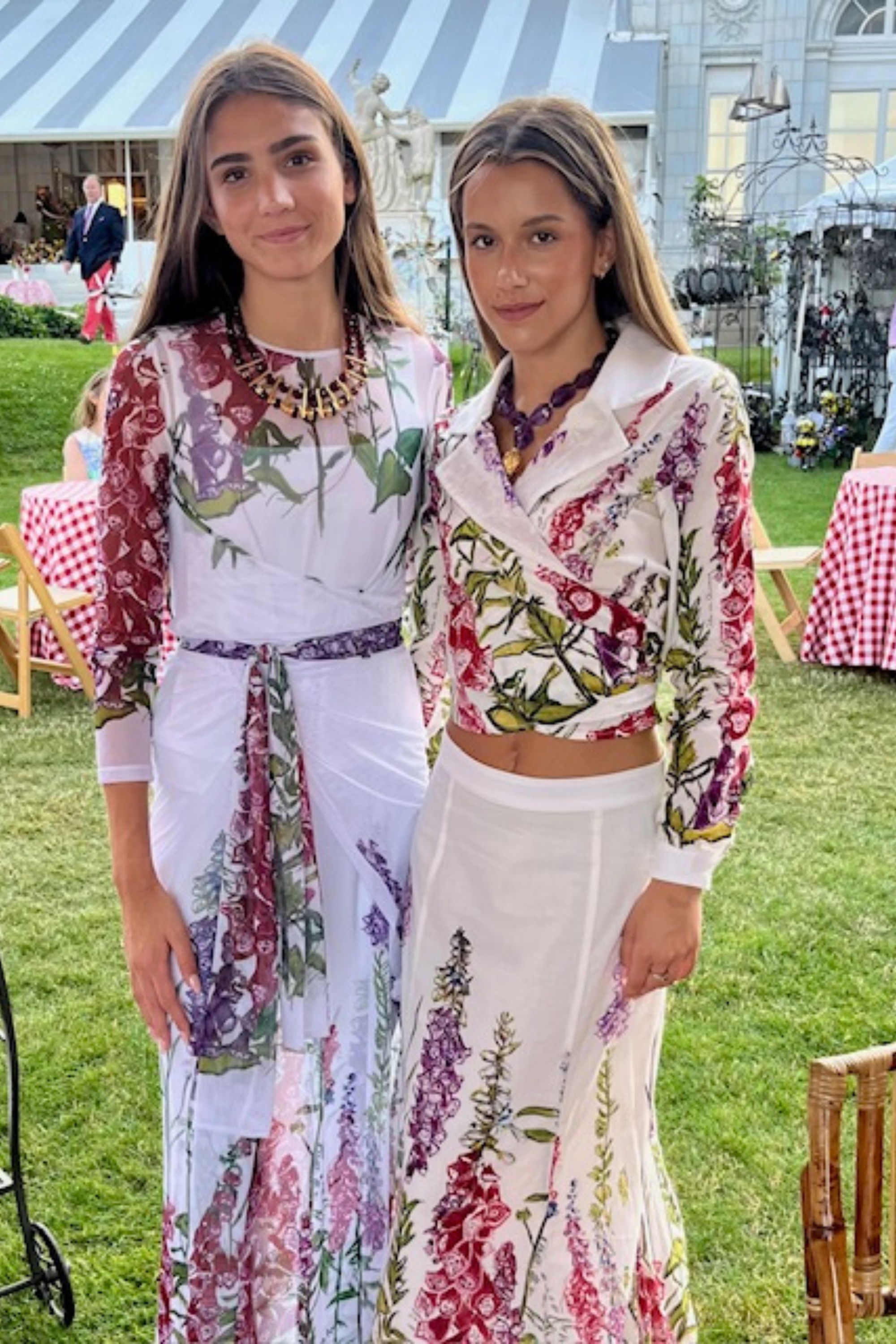 Two women wearing floral outfits by designer Ala von Auersperg for womens luxury travel clothing at the Newport Flower Show in Rhode Island at The Breakers Mansion