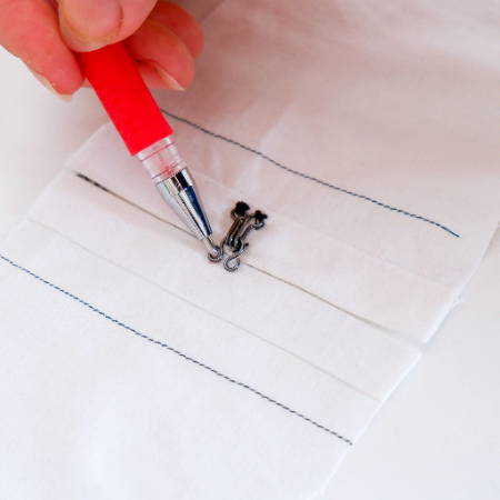Marking the position of the hook and eye closure with a heat erasable fabric marker