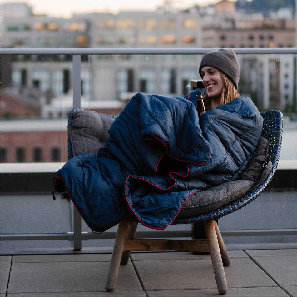 Kristen Petsche wrapped in a Rumpl blanket on a patio