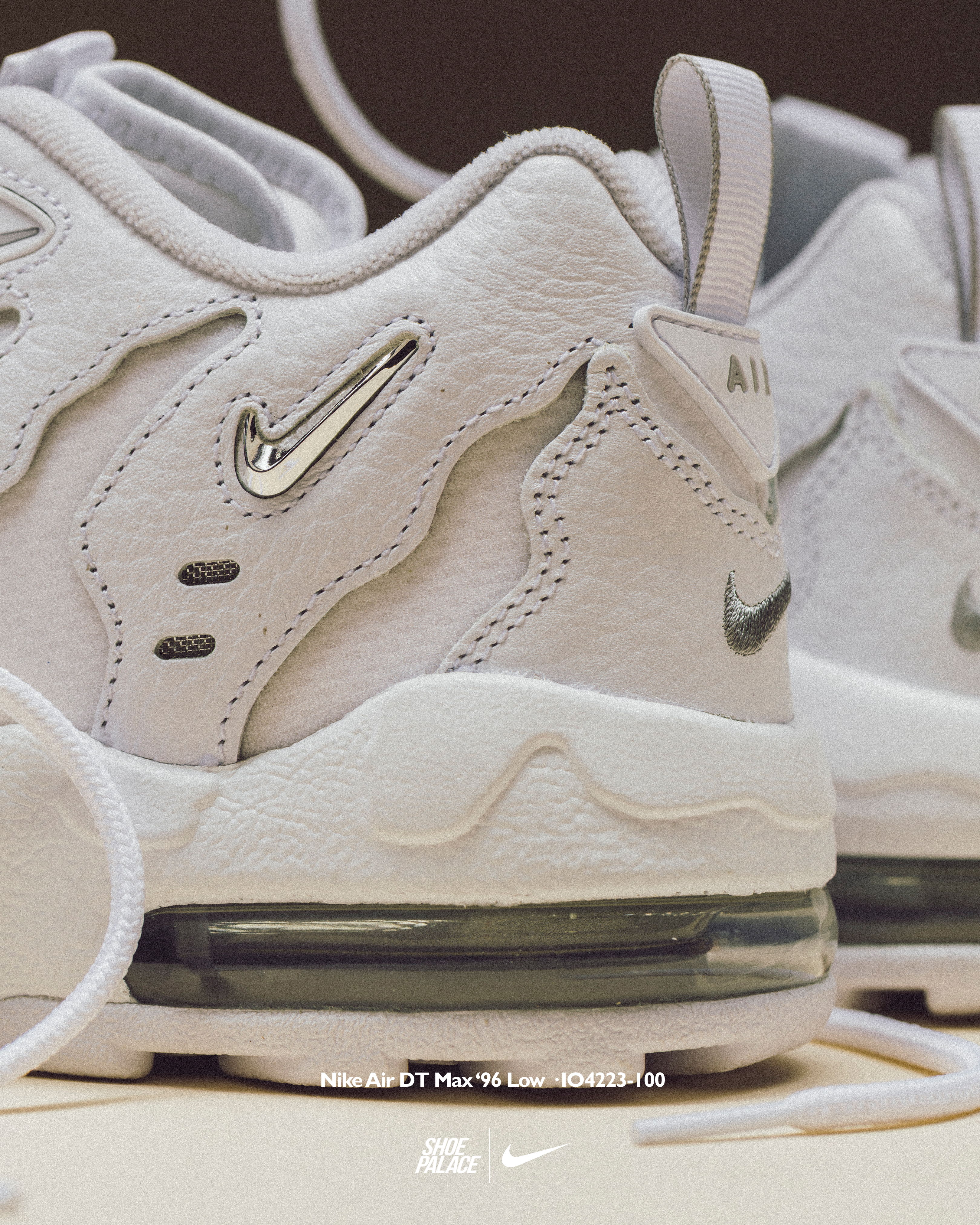 White Nike sneakers with reflective details and visible air cushioning.