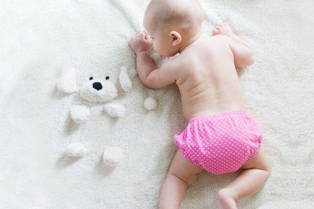 Baby Crawling On Bed Wearing Pink Bottoms