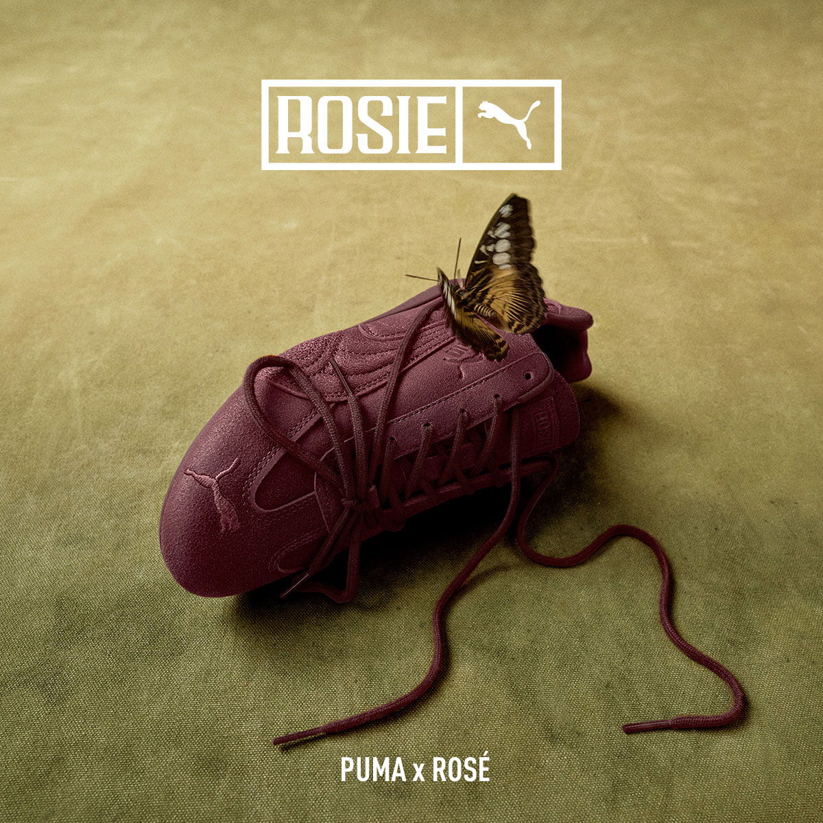 A maroon Puma shoe with a butterfly on top.