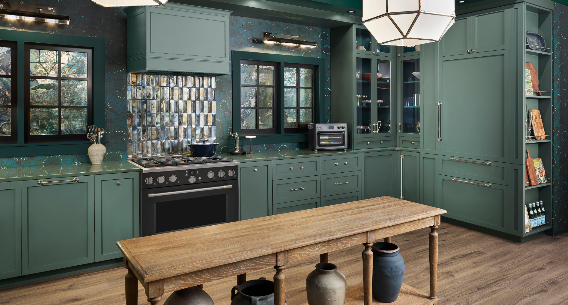 A modern kitchen featuring green cabinets and a wooden table.