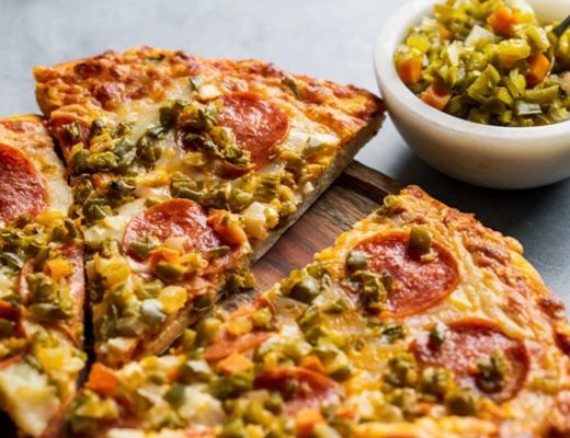 Slices of pepperoni pizza with a side of pickled vegetables.