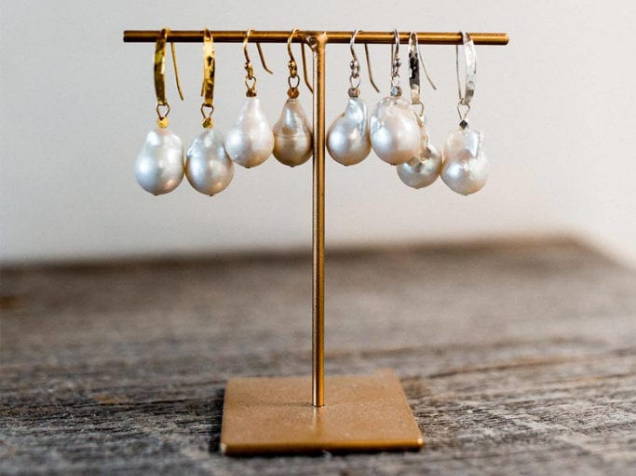 Pendiente de gota de perla en plata dorada y oro rosa sobre un soporte
