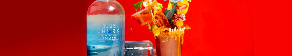 A bottle of water next to a colorful bouquet on a red background.