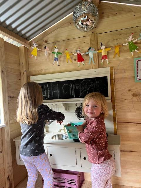 Kids playing in their wooden Cubby House