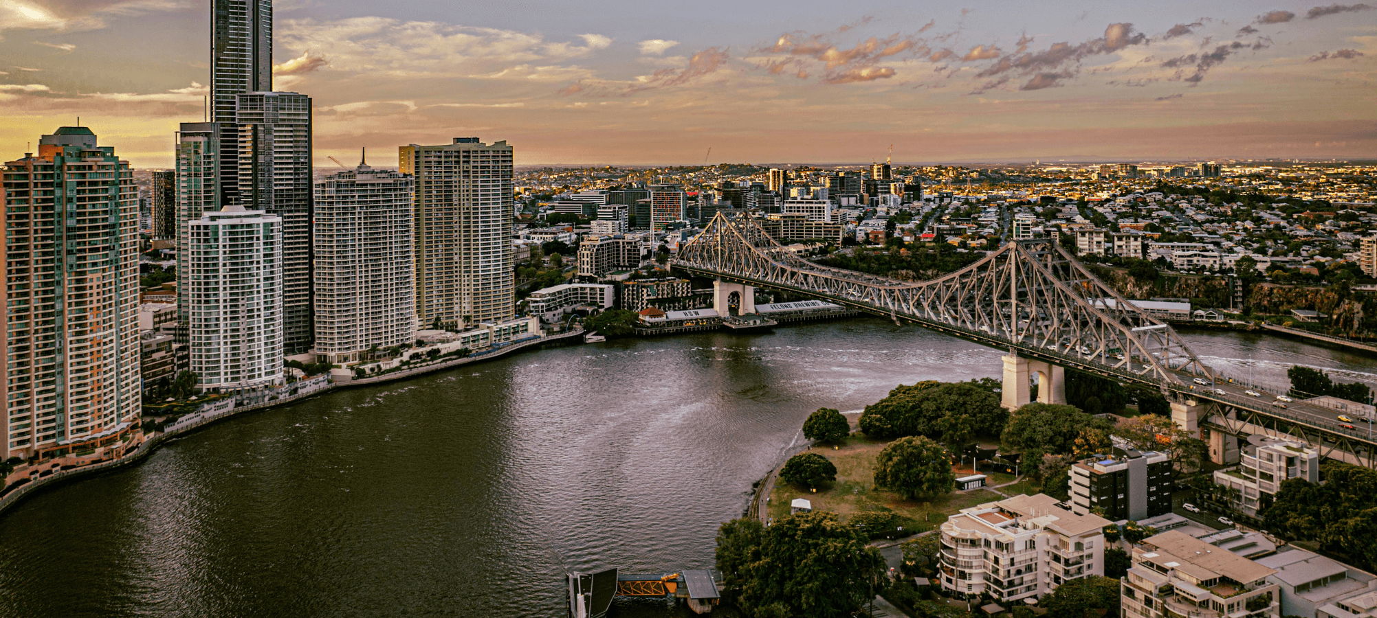 Brisbane City skyline at sunset with a river and the storey brisge where ebike rides enjoy the most