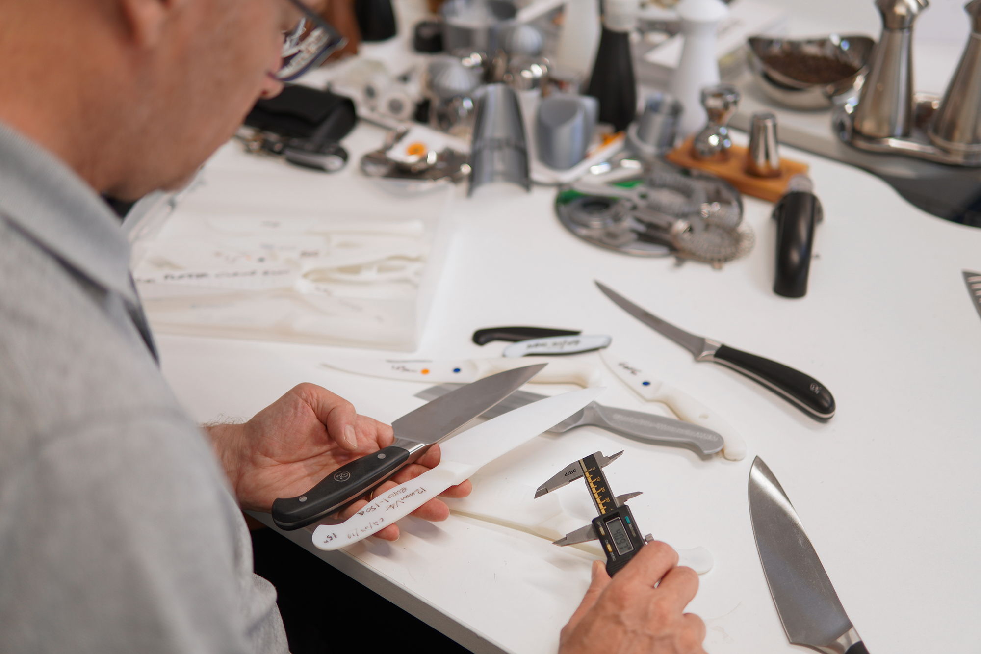 Paul examining knives with measuring instruments.