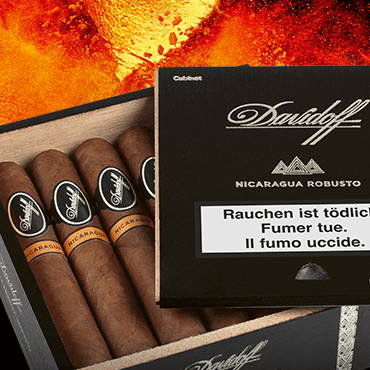 Davidoff Nicaragua Zigarren in ihrer Kiste mit geöffnetem Deckel. Feuer im Hintergrund.