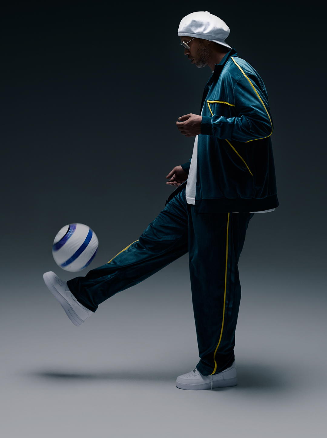 Ronaldinho in sporty attire juggling a soccer ball in a dimly lit setting.