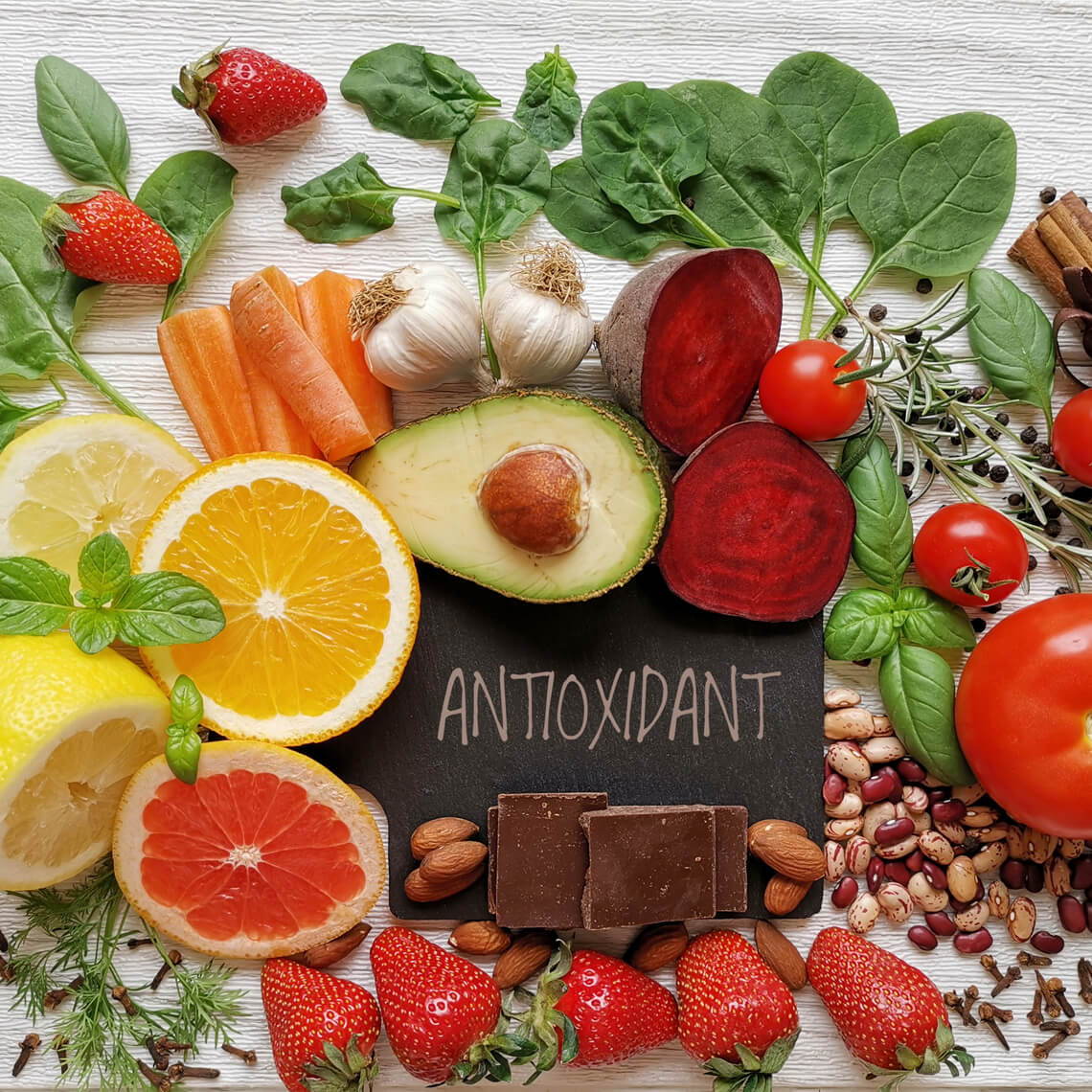 Colorful arrangement of fruits, vegetables, nuts, and chocolate labeled 