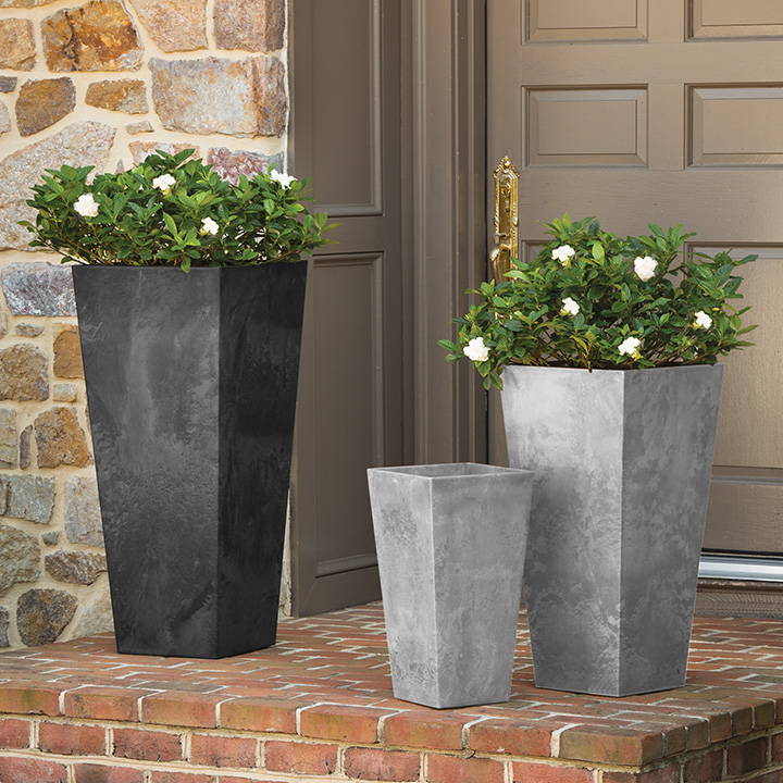 One black and two gray tall planters are sitting on the porch outside the front door