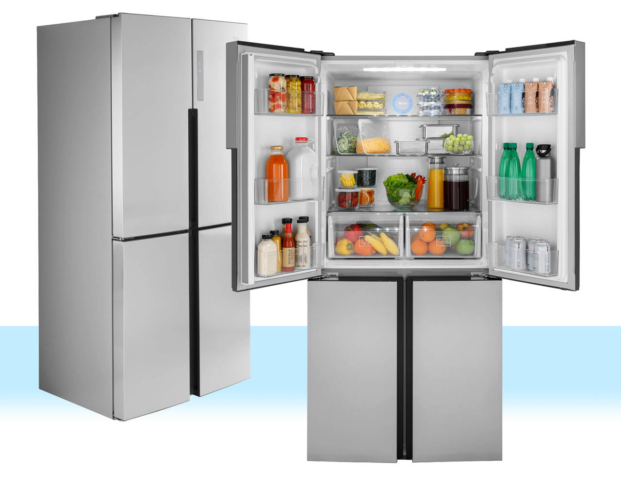 Two Haier refrigerators displayed side by side. One refrigerator's french doors are open to reveal a loaded refrigerator with food and drinks.
