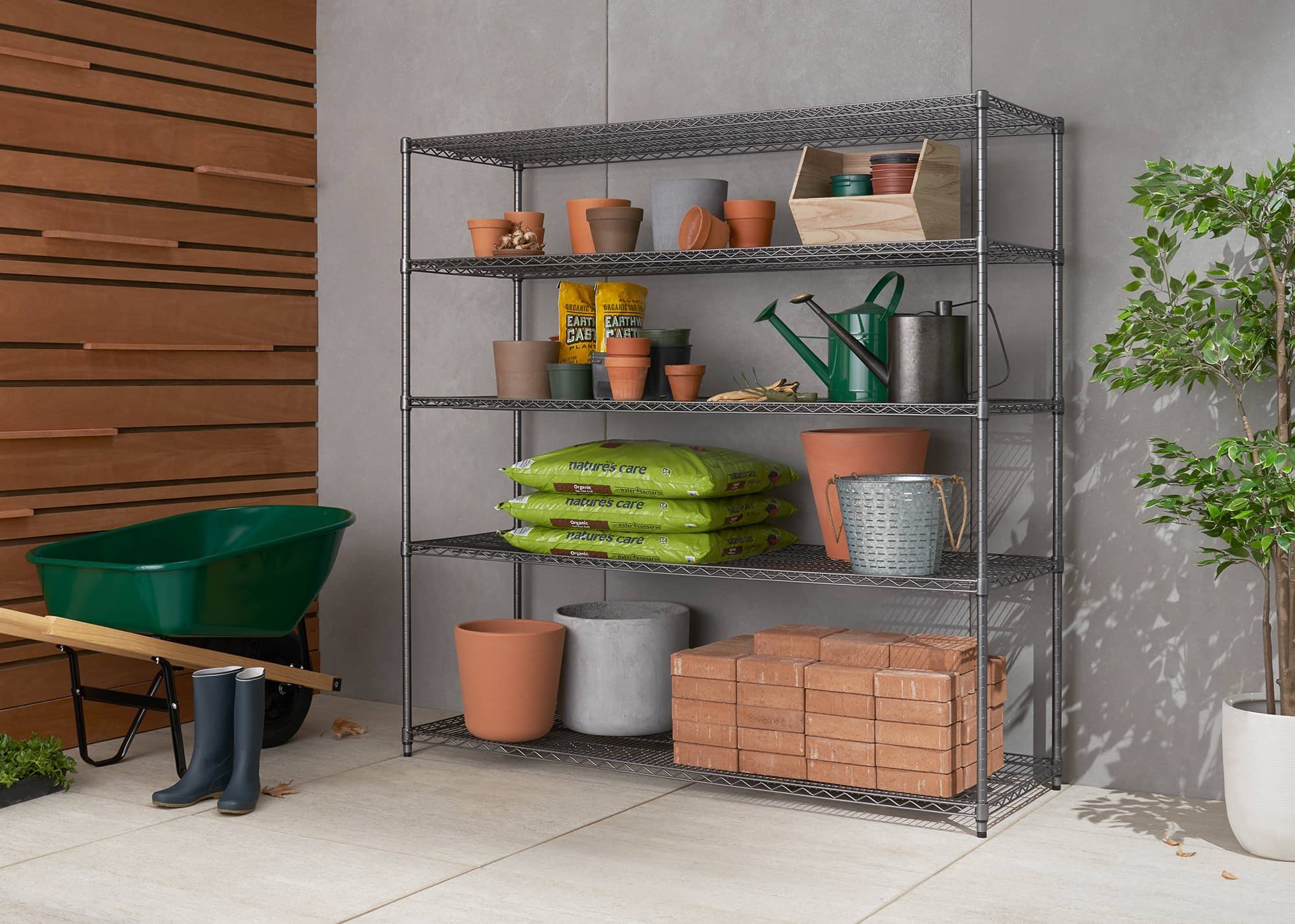 wide outdoor wire shelving rack filled with gardening tools and supplies