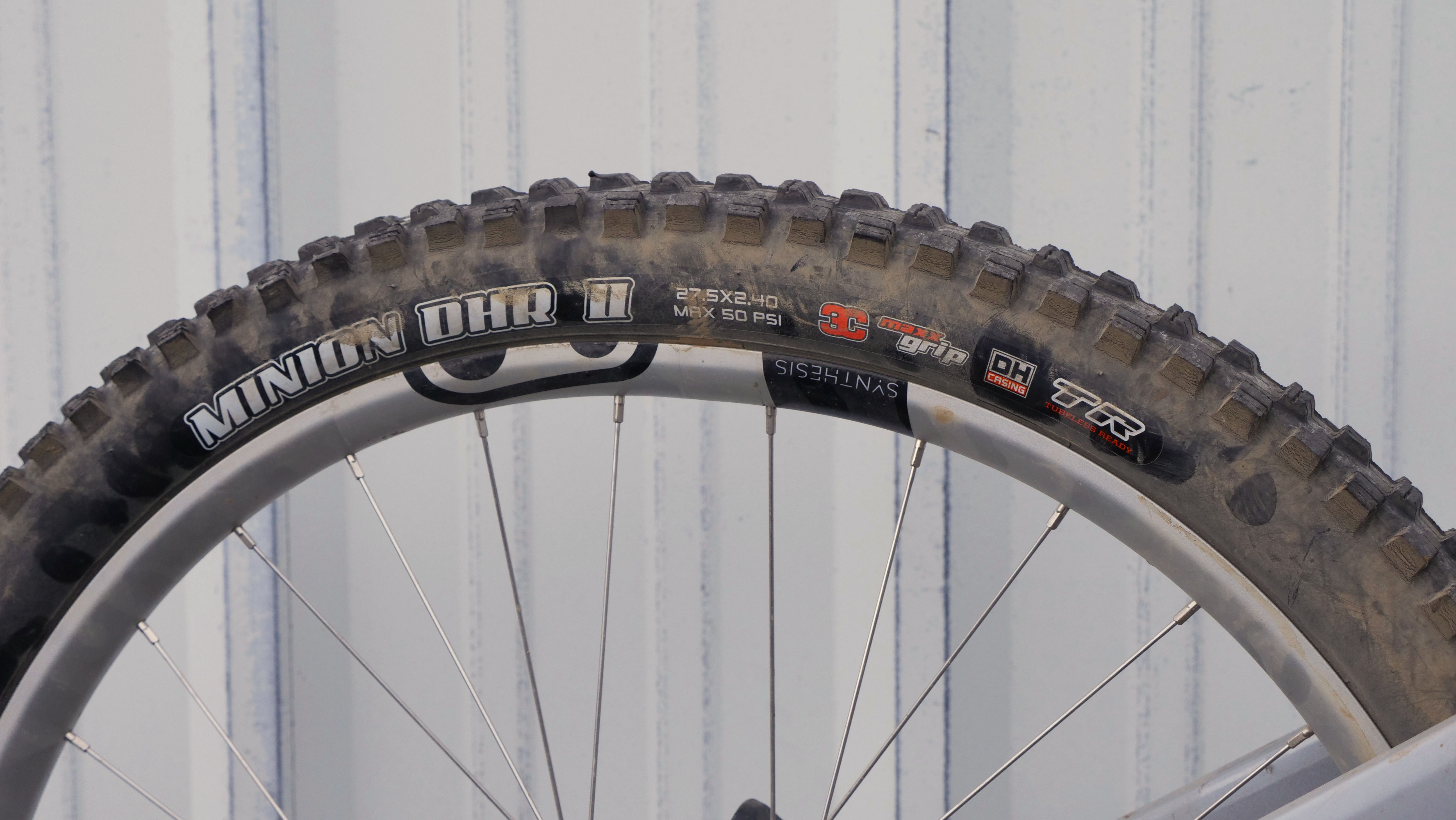 Close-up of a mountain bike tire against a gray background.