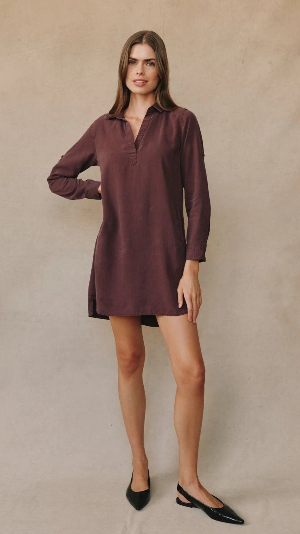 Model wearing a maroon dress with a collar and black flats.