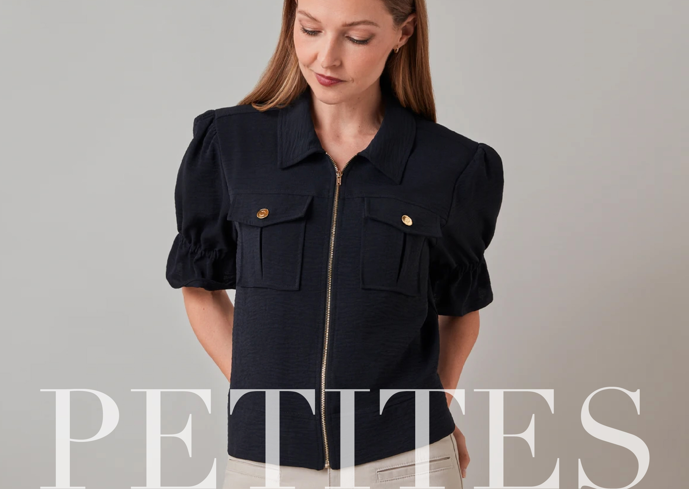 A woman in a navy shirt with puffed sleeves, looking down.